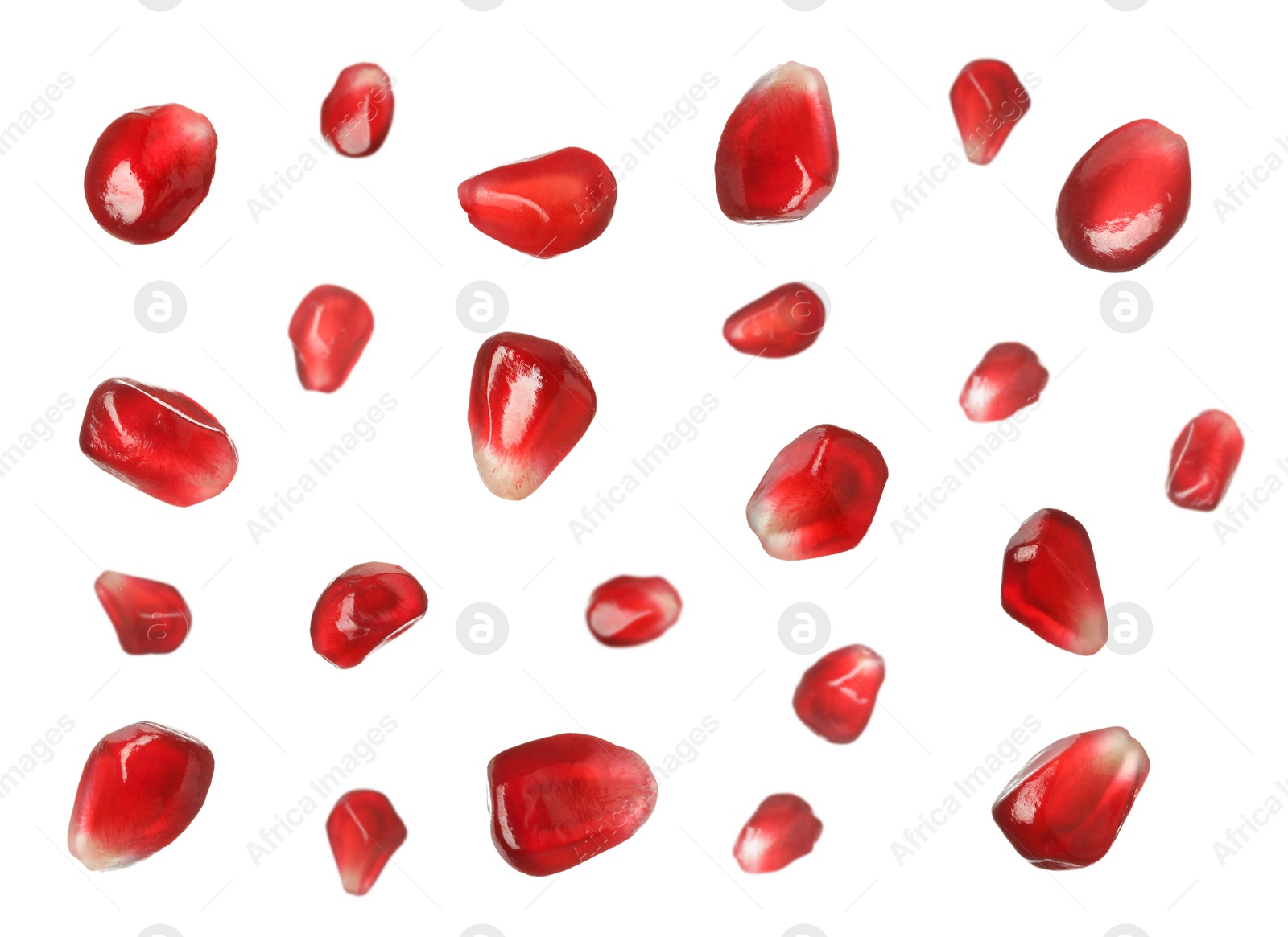 Image of Ripe juicy pomegranate seeds falling on white background 