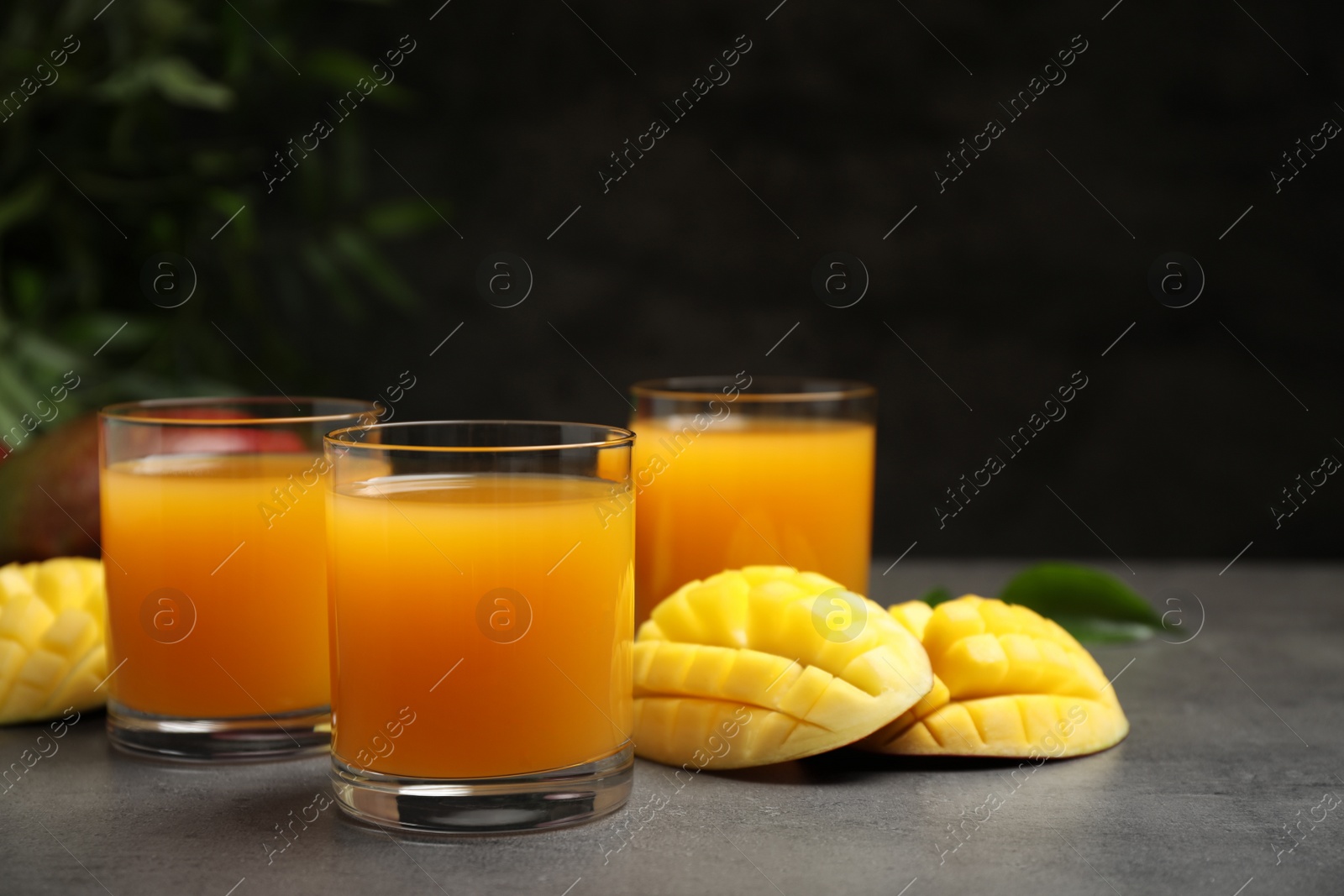 Photo of Fresh delicious mango drink on grey table