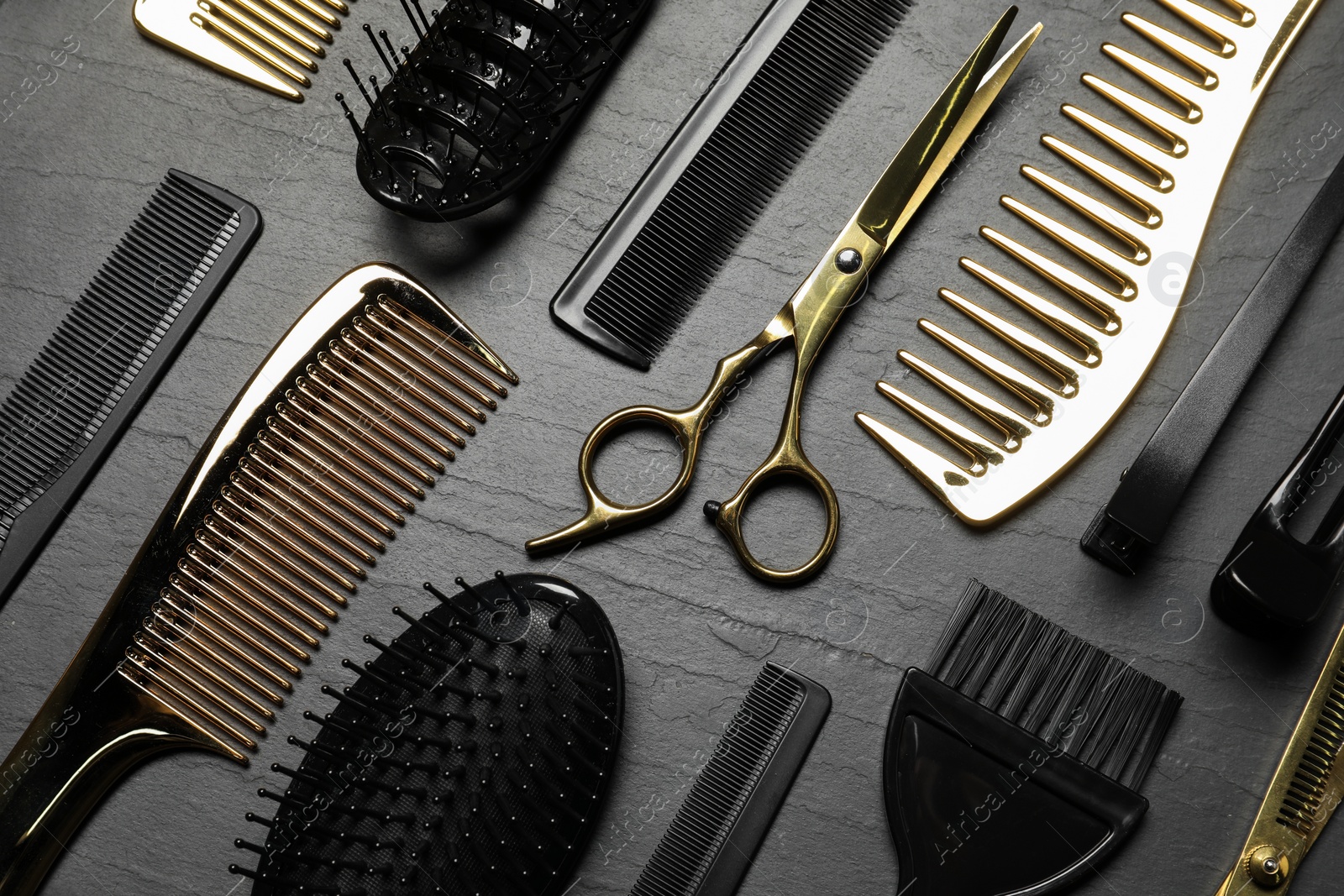 Photo of Hairdressing tools on grey textured background, flat lay