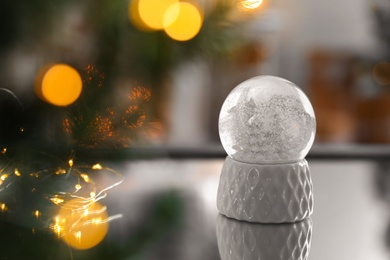 Decorative Christmas snow globe on mirror surface