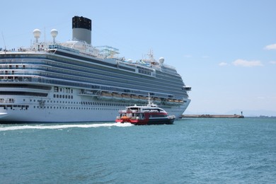 Photo of Modern cruise ship and boat in sea on sunny day