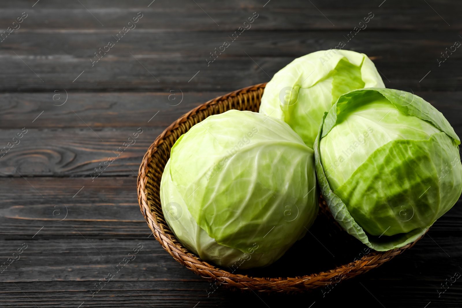 Photo of Ripe white cabbage on black wooden table