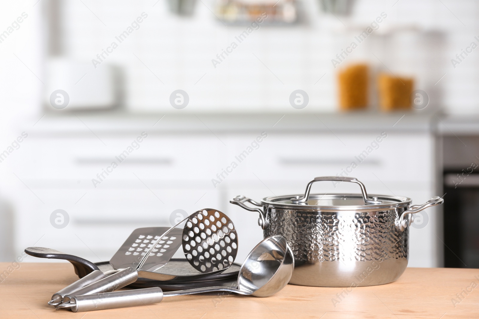 Photo of Set of clean cookware and utensils on table in kitchen. Space for text