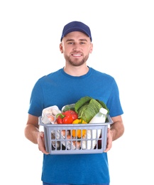 Photo of Delivery man holding plastic crate with food products on white background