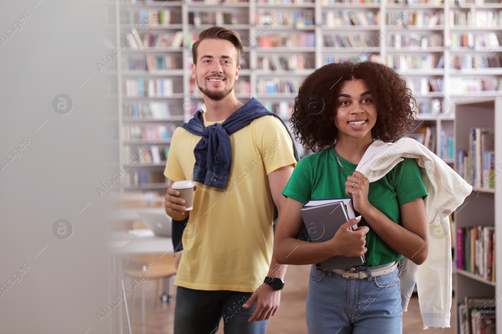 Photo of Happy young people with books in library