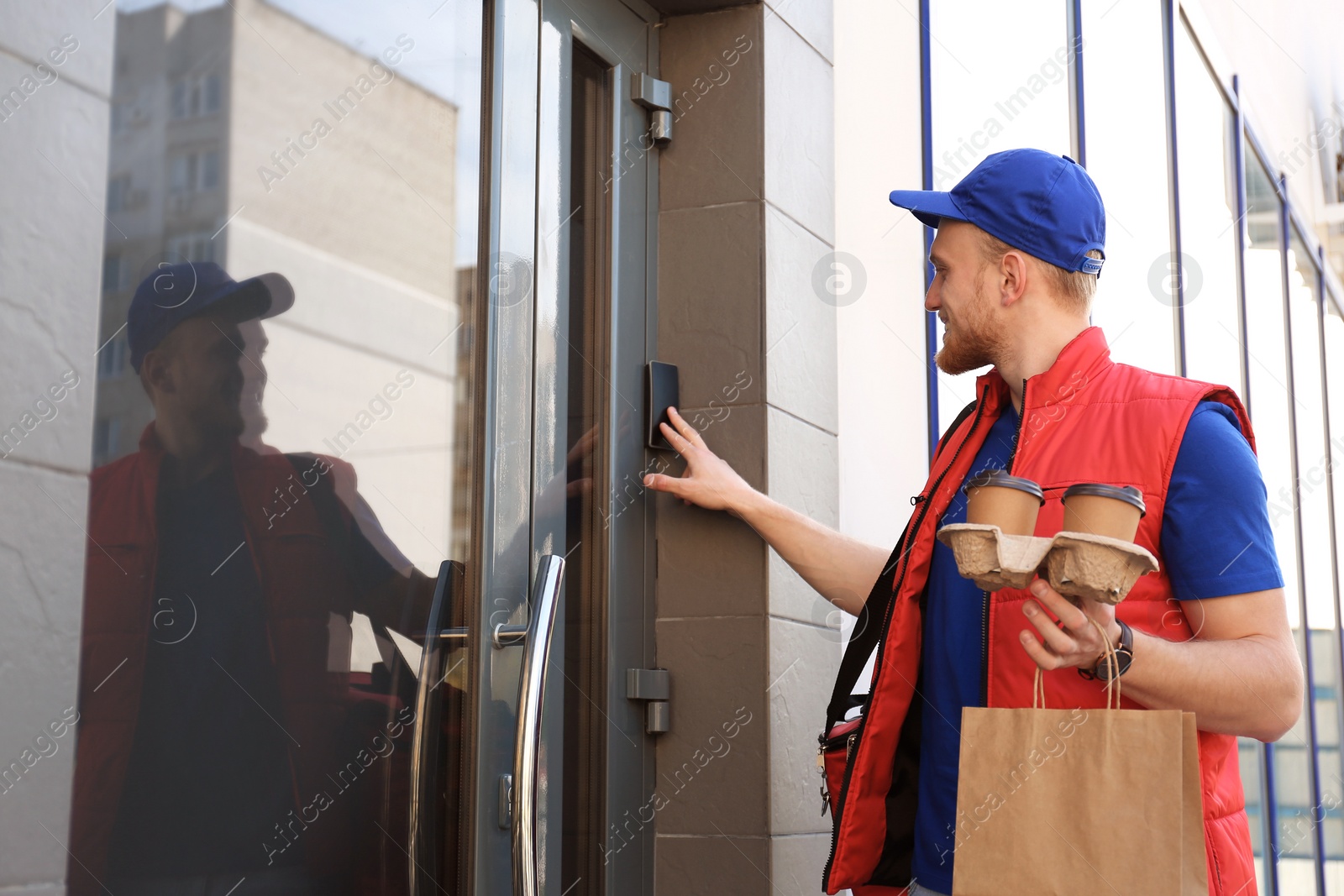Photo of Portrait of courier with order at door. Food delivery service