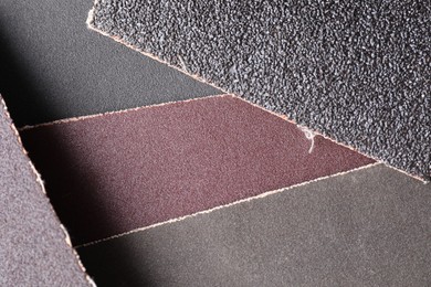 Photo of Many sheets of sandpaper as background, top view