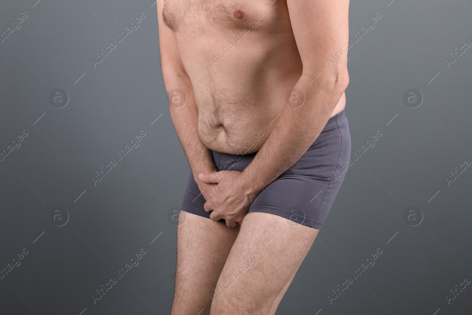 Photo of Mature man with urological problems suffering from pain on grey background