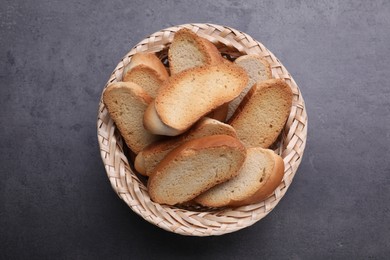 Photo of Hard chuck crackers in wicker basket on grey table, top view