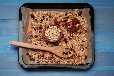 Tray with tasty granola, nuts and dry fruits on blue wooden table, top view