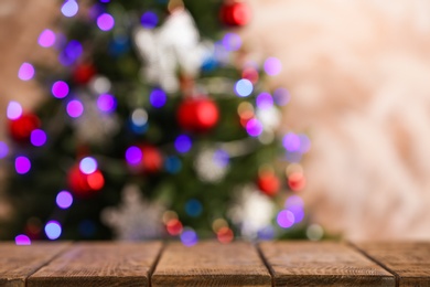 Photo of Empty wooden table and blurred fir tree with Christmas lights on background, bokeh effect. Space for design