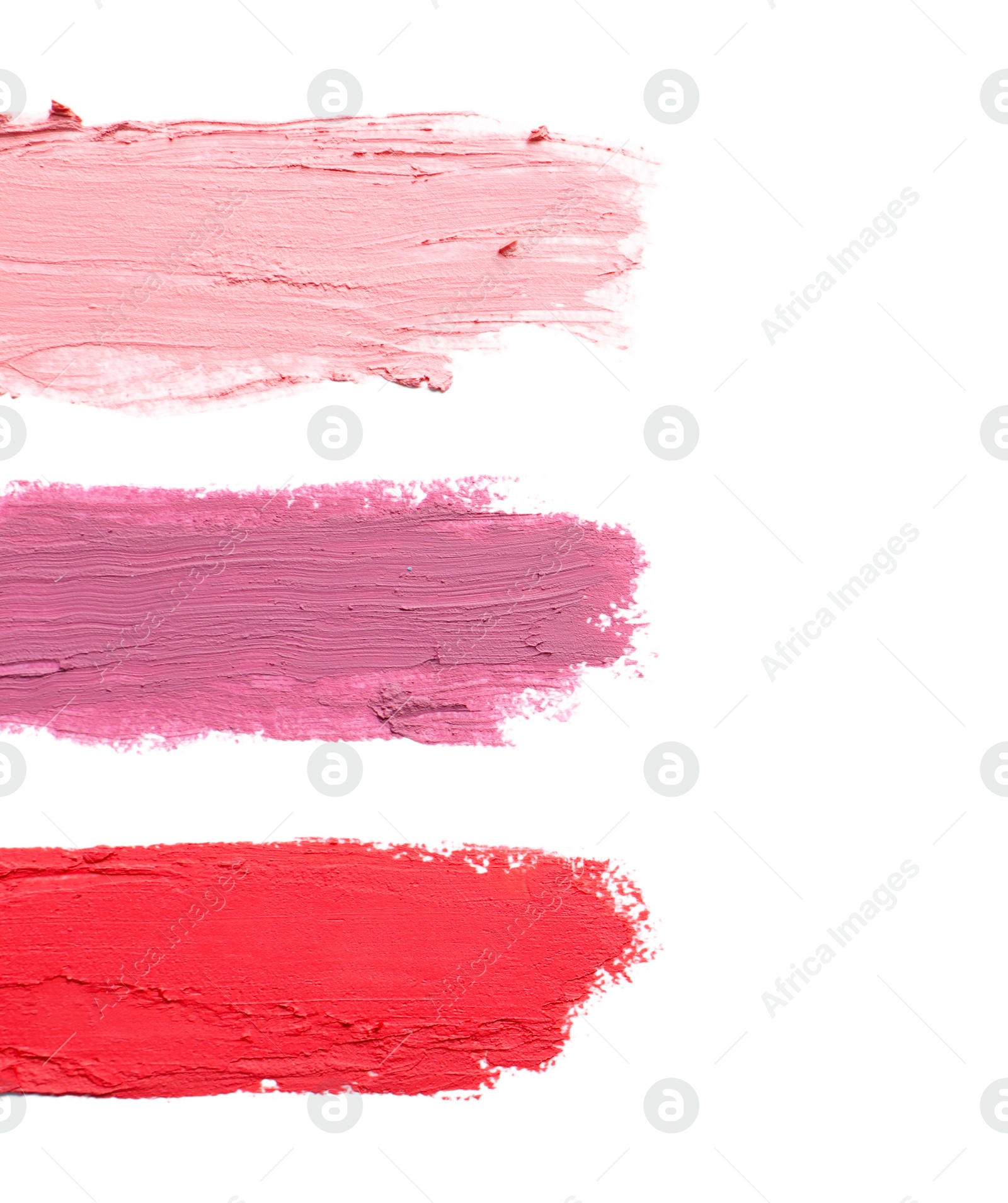 Photo of Strokes of lipstick on white background, top view