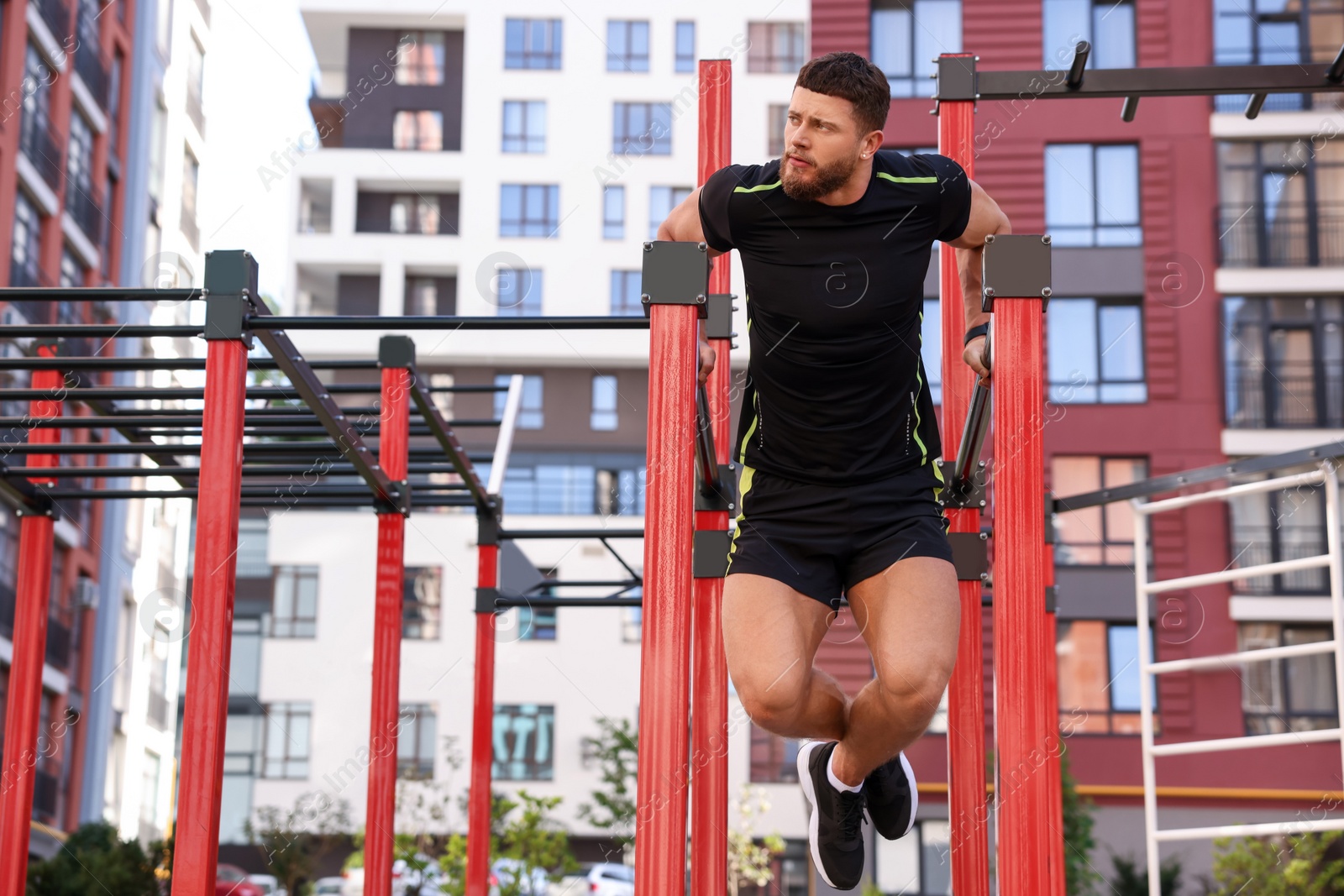 Photo of Man training on parallel bars at outdoor gym