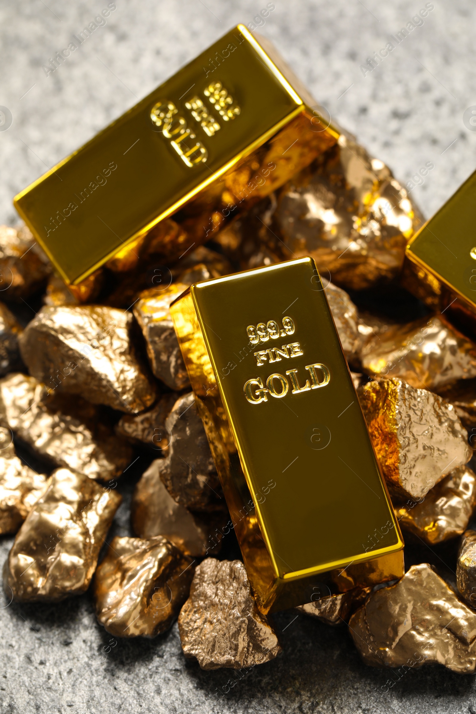 Photo of Gold ingots and nuggets on light grey table