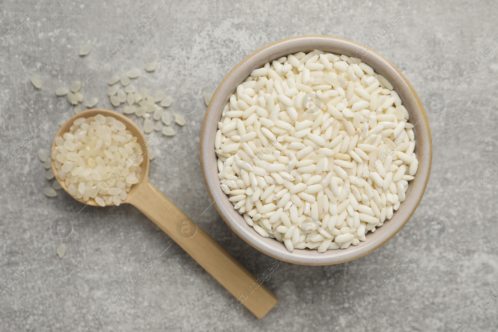 Photo of Different sorts of rice on grey table, flat lay