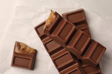 Photo of Tasty chocolate bars on white table, top view