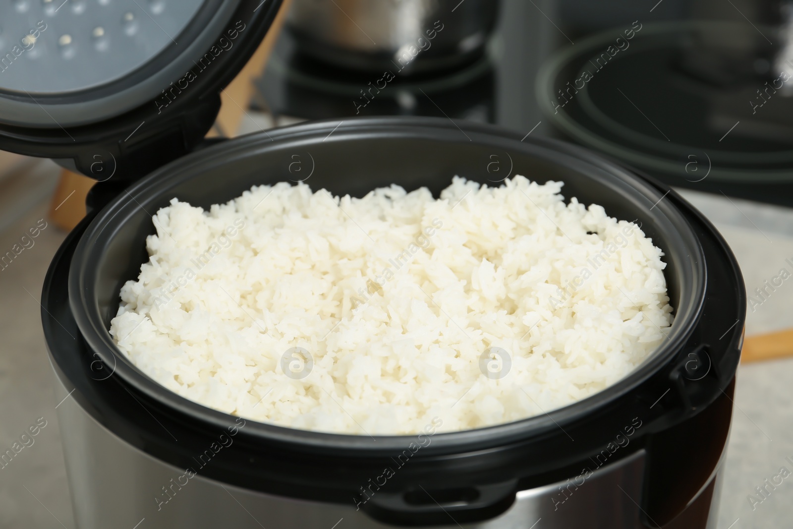 Photo of Modern cooker with fresh boiled rice in kitchen