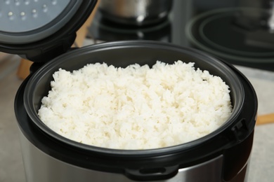 Photo of Modern cooker with fresh boiled rice in kitchen