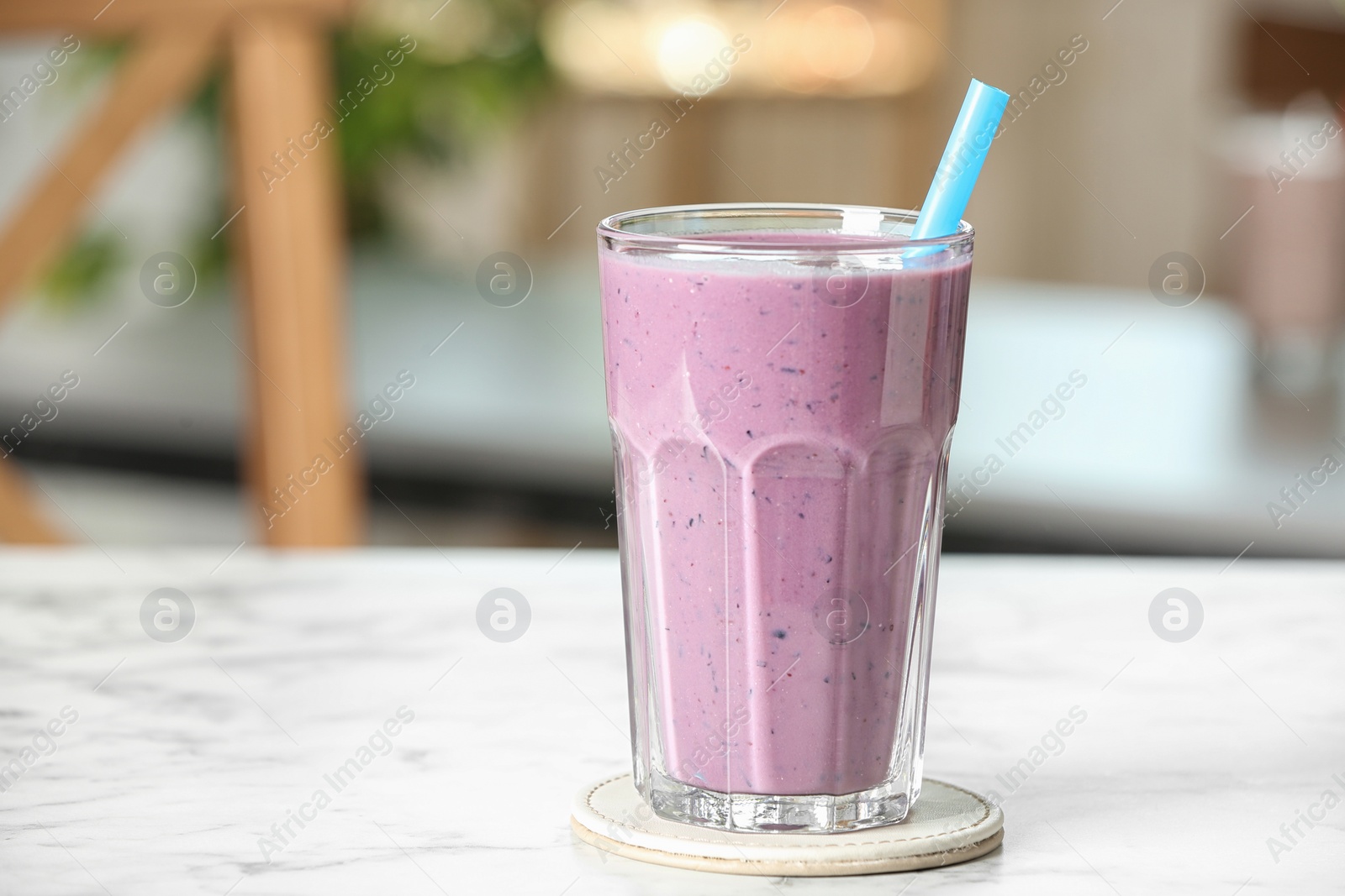 Photo of Tasty milk shake on white marble table indoors