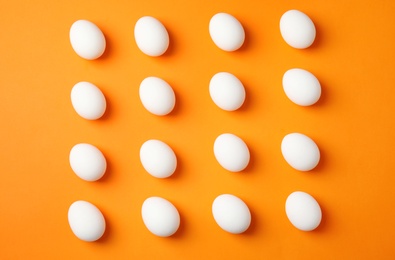 Photo of Raw chicken eggs on color background, top view