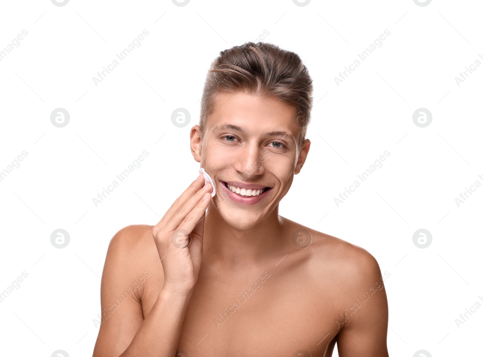 Photo of Handsome man cleaning face with cotton pad on white background