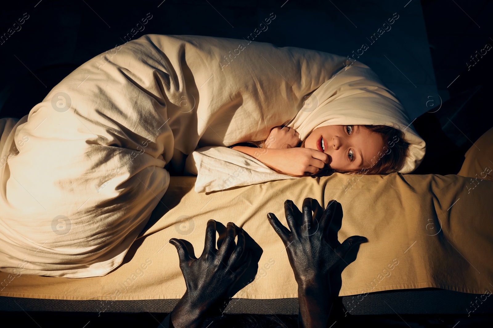 Photo of Childhood phobia. Scared girl and monster under bed at home, closeup