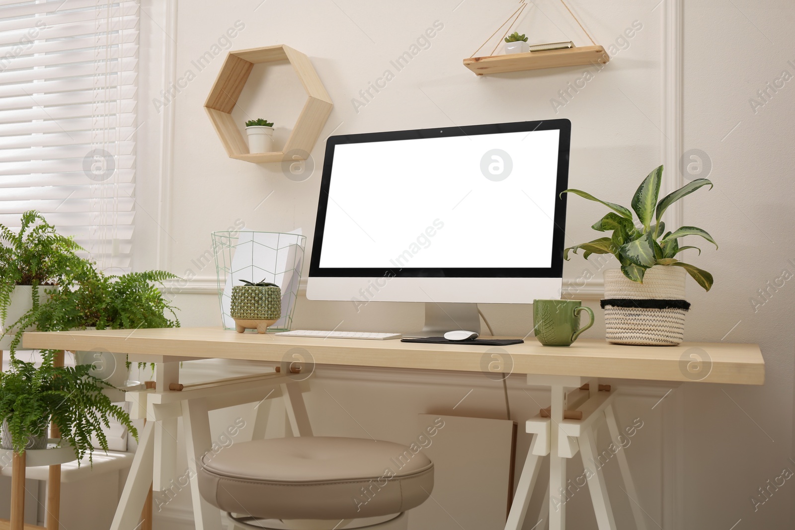 Photo of Comfortable workplace with modern computer and houseplants in room. Interior design