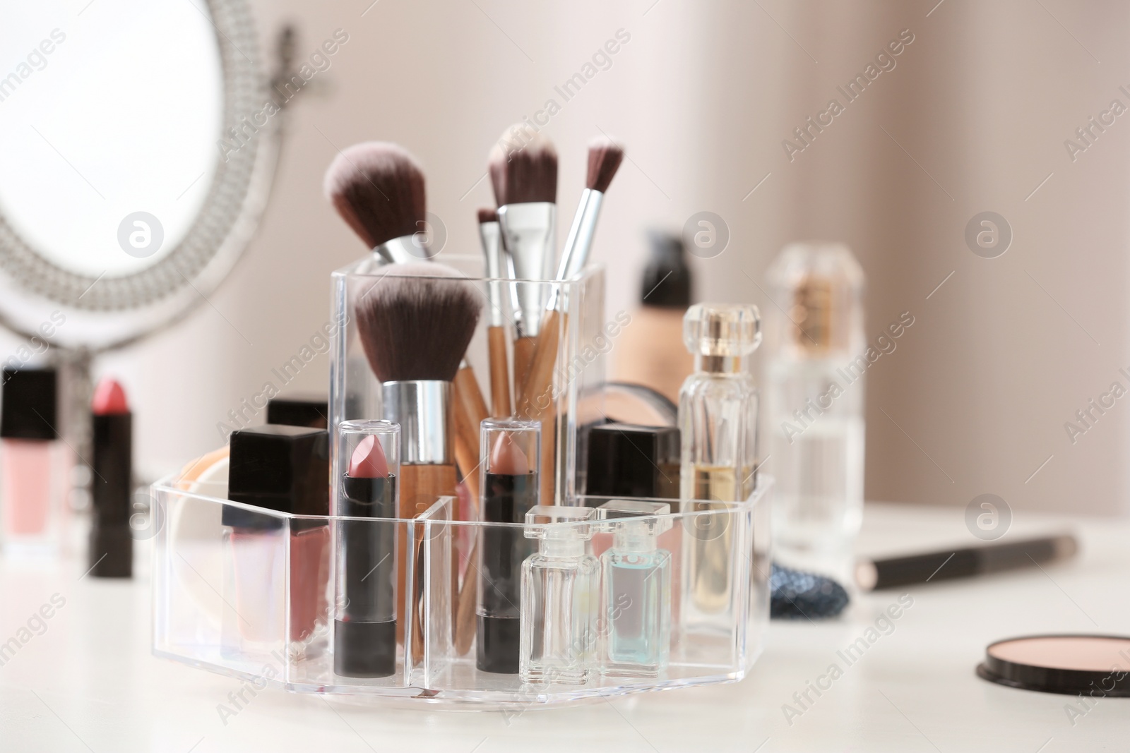 Photo of Makeup accessories and cosmetic products on table against blurred background