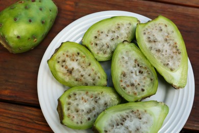 Photo of Tasty prickly pear fruits on wooden table, top view