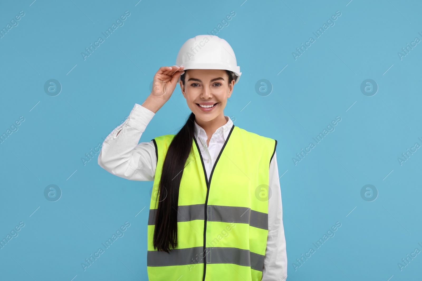 Photo of Engineer in hard hat on light blue background