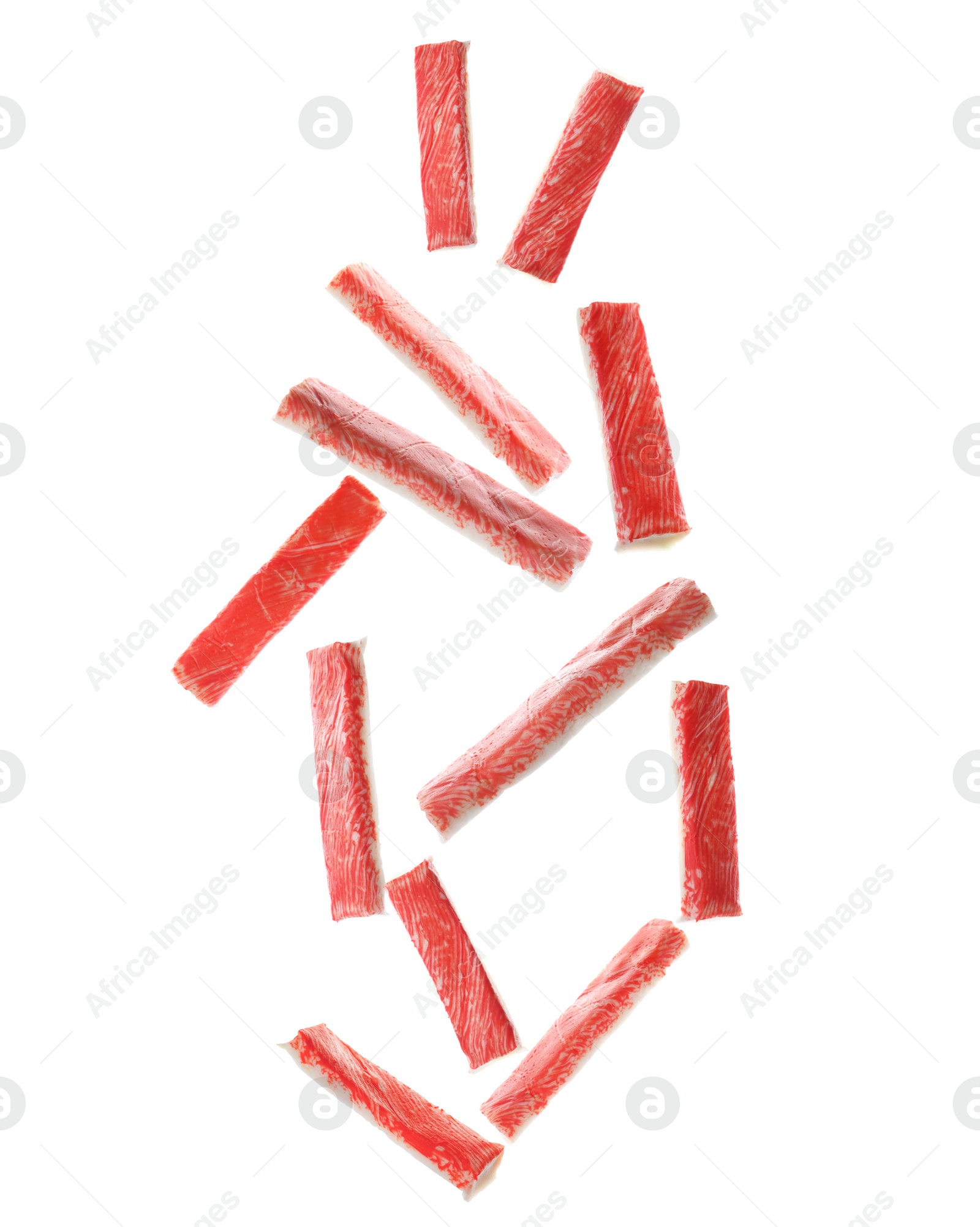 Image of Many fresh crab sticks falling on white background