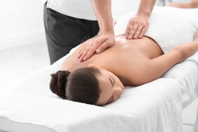 Photo of Relaxed woman receiving back massage in wellness center