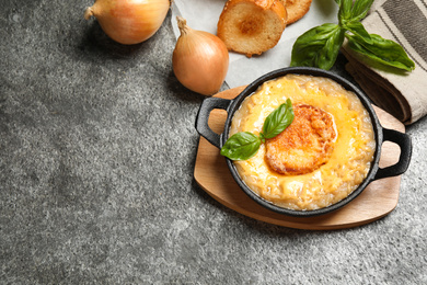 Photo of Tasty homemade french onion soup served on grey table, flat lay. Space for text