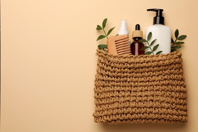 Preparation for spa. Compact toiletry bag with different cosmetic products on light brown background, flat lay. Space for text