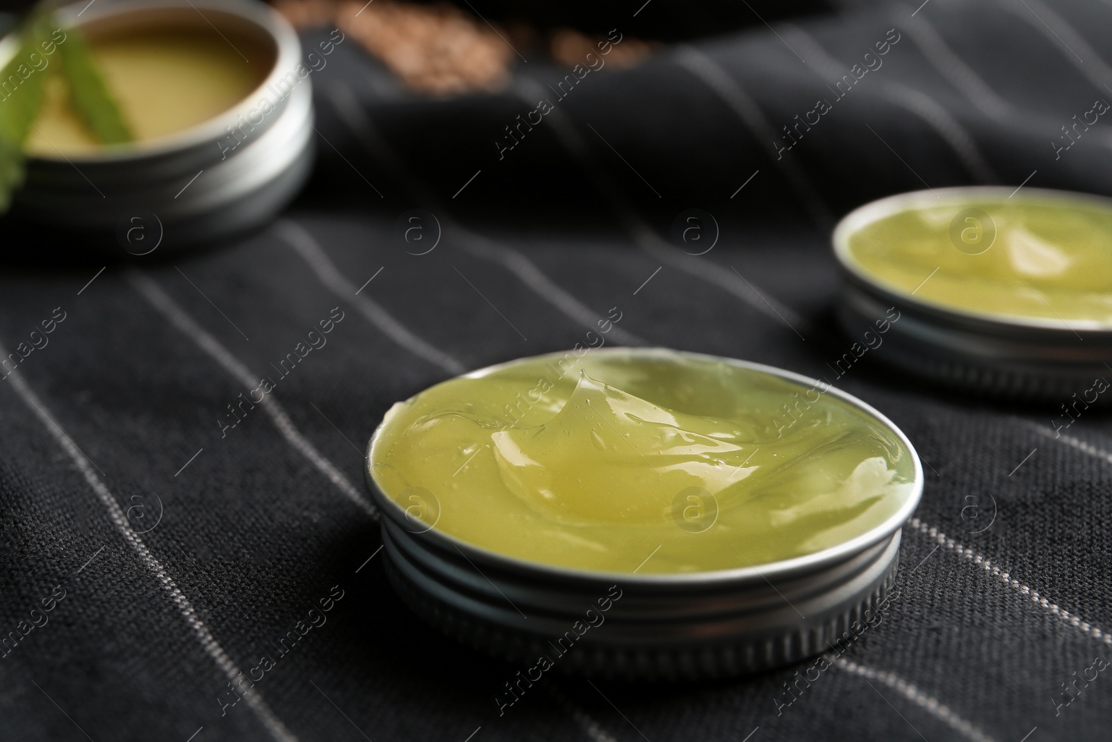 Photo of Jar lid with hemp lotion on striped fabric