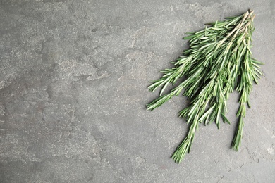 Photo of Fresh rosemary twigs on grey background, above view. Space for text