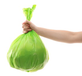 Photo of Woman holding plastic bag full of garbage on white background, closeup