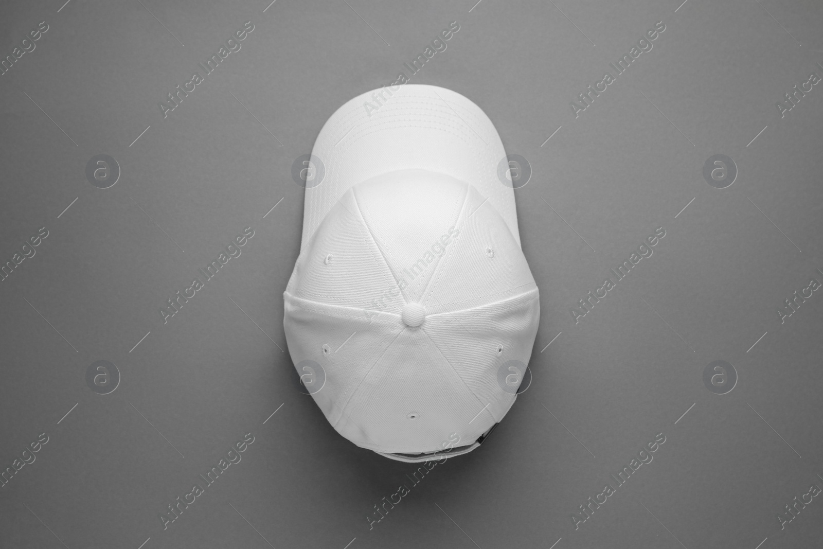 Photo of Stylish white baseball cap on grey background, top view