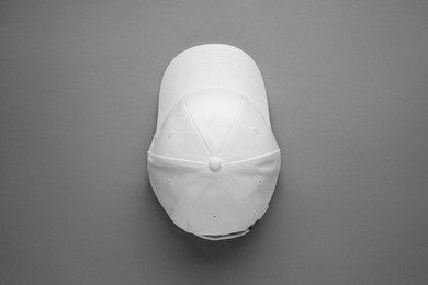 Stylish white baseball cap on grey background, top view