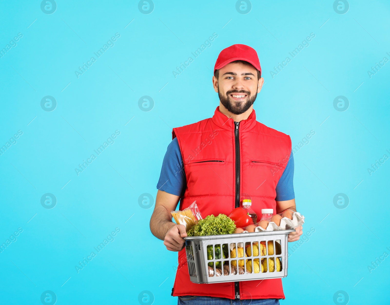 Photo of Man holding basket with fresh products on color background, space for text. Food delivery service