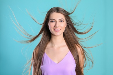 Photo of Portrait of young woman with long beautiful hair on color background