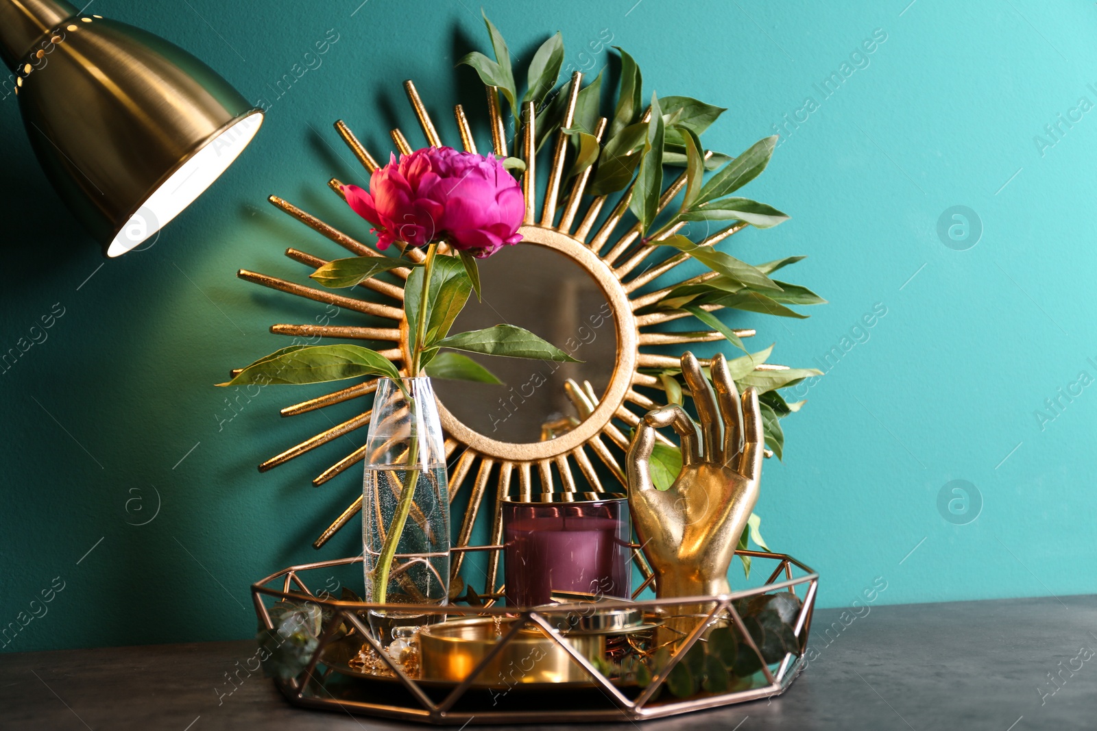 Photo of Composition with stylish accessories and interior elements on table near turquoise wall