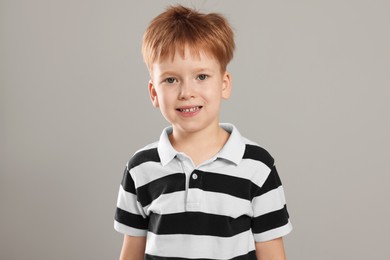 Portrait of cute little boy on light grey background