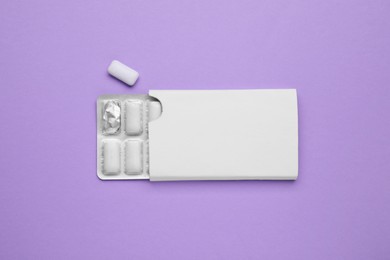 Photo of Blister with chewing gums on violet background, top view