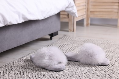 Photo of Grey soft slippers on carpet at home