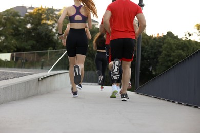 Group of people running outdoors, back view
