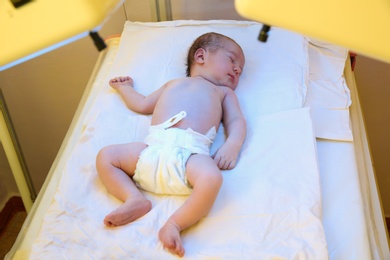 Newborn child under ultraviolet light in hospital