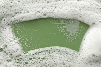 White washing foam on olive background, top view
