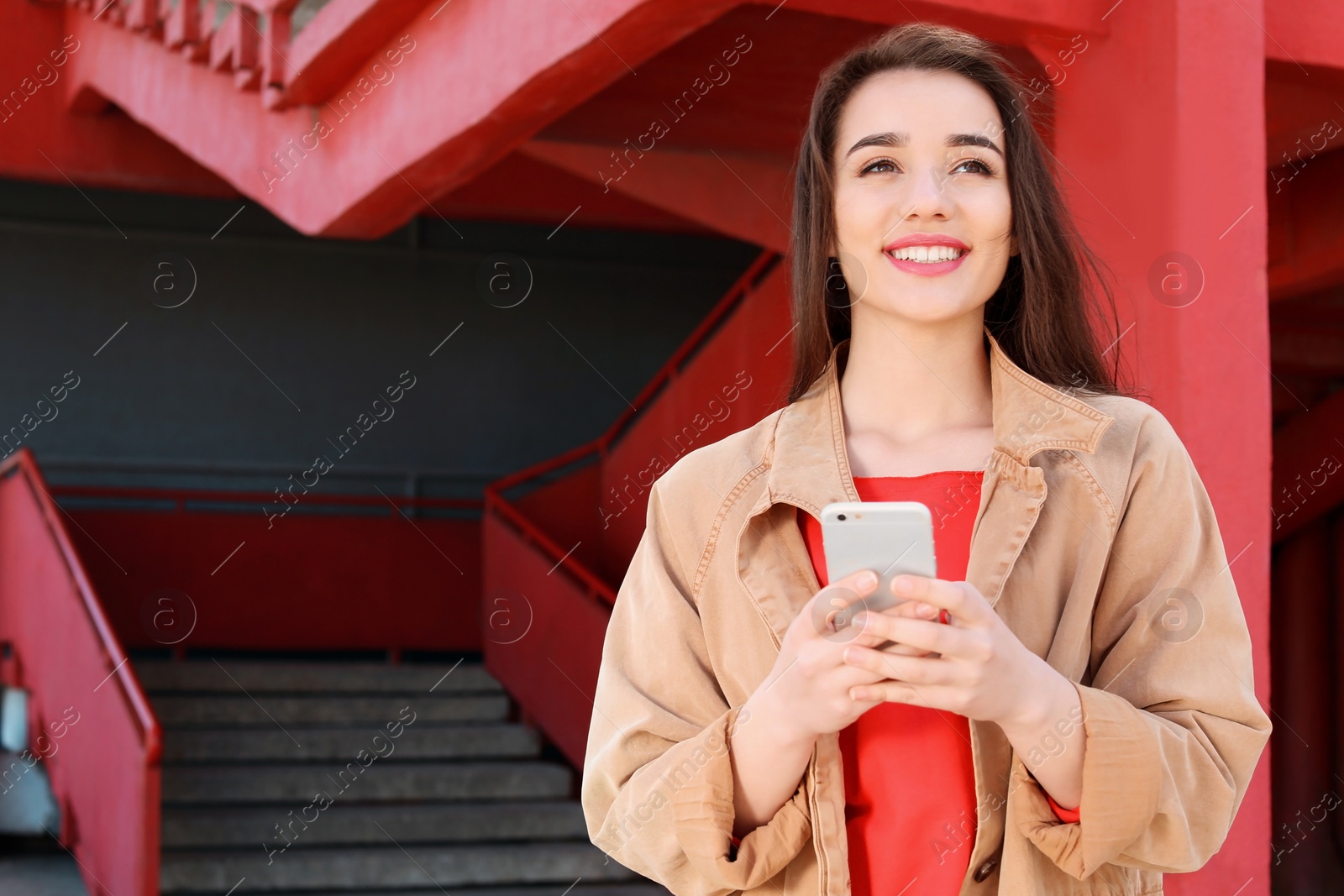 Photo of Young woman using mobile phone outdoors