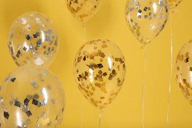 Photo of Bright balloons with ribbons on color background